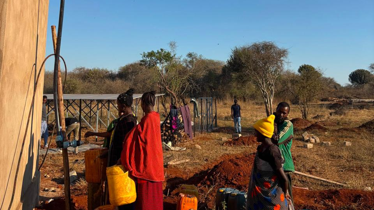 Community members collecting water from a solar-powered borehole in Tanzania